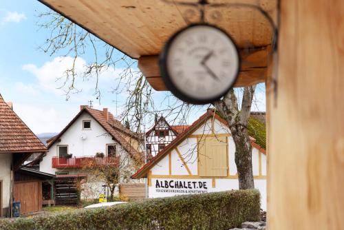 een klok die aan de zijkant van een gebouw hangt bij Albchalet in Rosenfeld