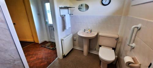 a small bathroom with a toilet and a sink at Glenterry Farmhouse in Kirkcudbright