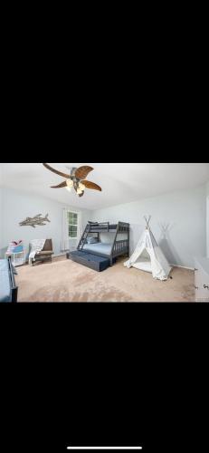 1 dormitorio con ventilador de techo y tienda de juegos en Verona Beach House, 