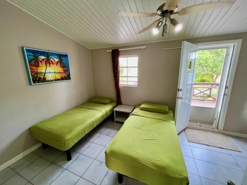 a room with two beds and a ceiling fan at South Finger Villa in Jolly Harbour