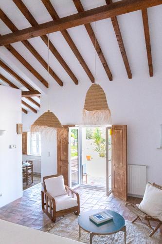 a living room with white walls and wooden ceilings at Casa Litoral in Melides