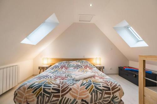 a bedroom with a bed and skylights in the attic at Manoir de Kervegan : Le Logis du P’tit Levant in Lannion
