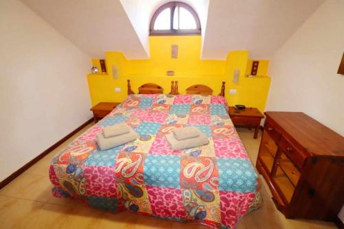 1 dormitorio con 1 cama grande y colcha colorida en Parque Santiago II 379 Tenerife Rental and Sales, en Playa de las Américas