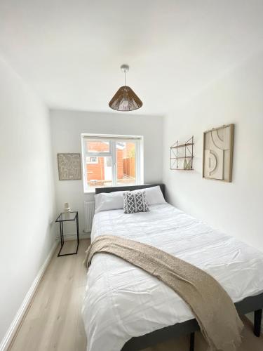 a white bedroom with a large bed in it at Retro 3 bed, 2 En-suite Haven in Birmingham