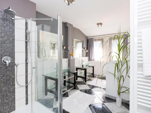 a bathroom with a glass shower stall and a sink at Hotel Zur Heidschnucke in Asendorf