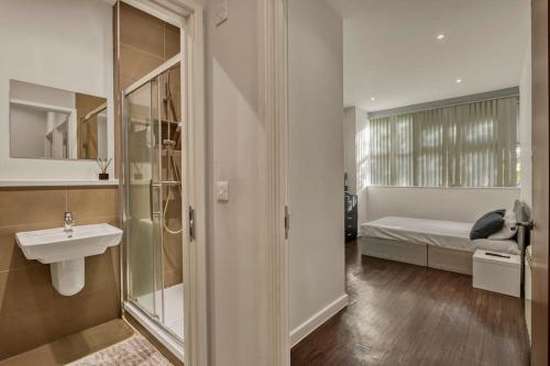 a bathroom with a sink and a bedroom with a bed at Chic 1 Bedroom Apartment in London