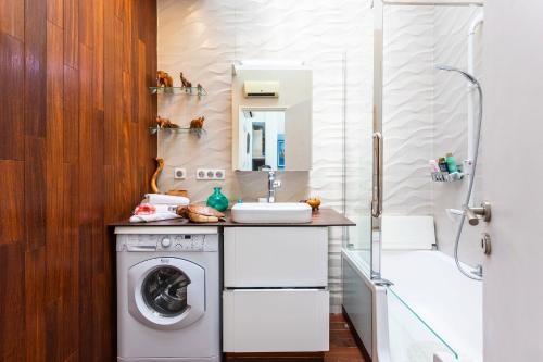 une salle de bain avec une machine à laver et un lavabo dans l'établissement LE FRANCE AP4350 By Riviera Holiday Homes, à Nice