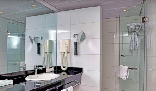 a bathroom with a sink and a shower at Eko Hotel Gardens in Lagos