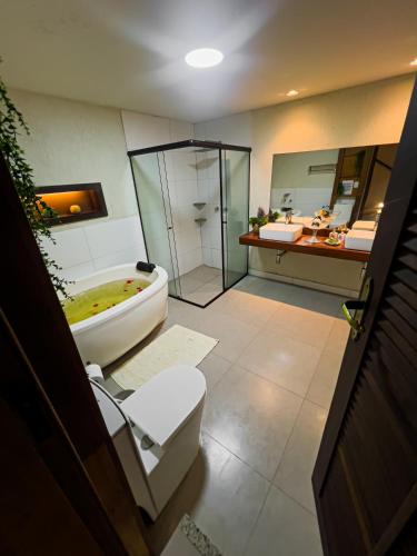 a bathroom with a tub and a shower and a toilet at Espaço Viverde Penedo in Penedo