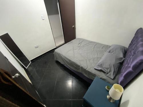 a small bedroom with a bed and a table at Casa 72 in Barranquilla