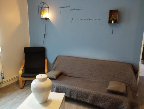 una habitación con una cama y un jarrón sobre una mesa en Le Grèbe en Le Tréport