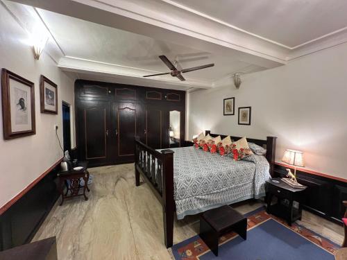 a bedroom with a bed and a ceiling fan at Vijai Mahal - A Colonial Homestay in Ajmer