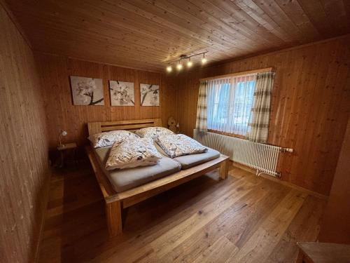 a bedroom with a bed in a wooden room at Latura - 3.5 Zimmerwohnung für 4 Personen, 80m2 in Buchen