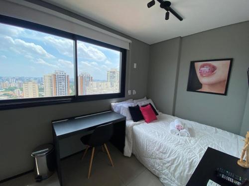 a bedroom with a bed and a desk and a window at Studio Vl Mariana-ao lado Facul ESPM in Sao Paulo