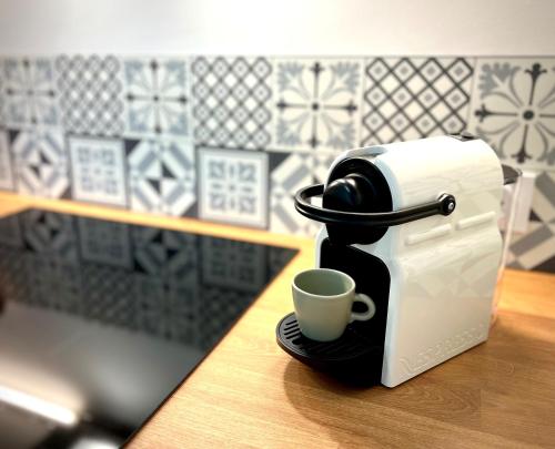 eine Kaffeemaschine auf einer Theke mit einer Tasse in der Unterkunft T2 Hyper centre 3 étoiles Rue du Casino in Aix-les-Bains