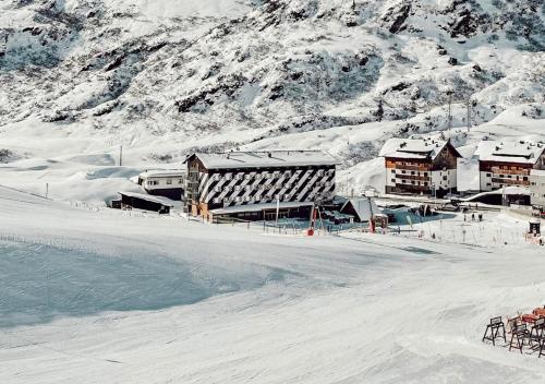 a building in the snow next to a mountain at Hit the Sky in Sankt Christoph am Arlberg