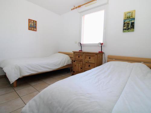 - une chambre avec deux lits, une fenêtre et une commode dans l'établissement Saint Cyprien : Appartement T3 avec Toit Terrasse, Piscine et Accès Direct à la Plage - FR-1-309-357, à Saint-Cyprien