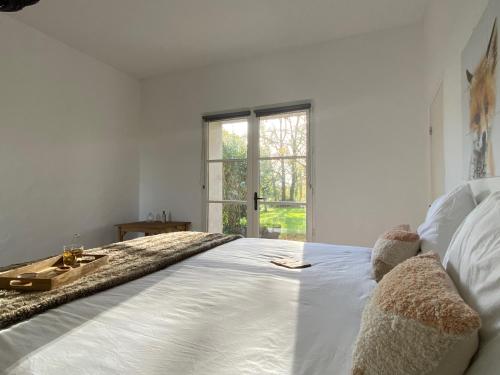 una cama blanca con dos ositos de peluche sentados en ella en Domaine la Boulinière - Le Sanglier, en Journet
