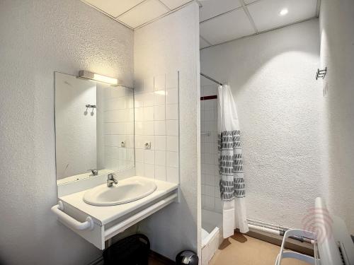 une salle de bain blanche avec un lavabo et une douche dans l'établissement Charmant Studio en Centre-Ville, Proche Thermes avec Balcons et Wifi – Animaux Acceptés - FR-1-451-177, à Lamalou-les-Bains