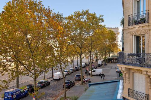 - une vue sur une rue de la ville avec des voitures garées dans l'établissement Appartement exceptionnel avec terrasse en plein coeur de Paris - Welkeys, à Paris