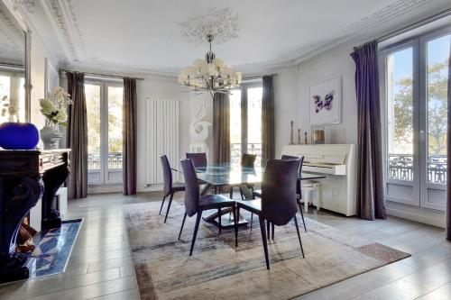 - une salle à manger avec une table, des chaises et un piano dans l'établissement Appartement exceptionnel avec terrasse en plein coeur de Paris - Welkeys, à Paris