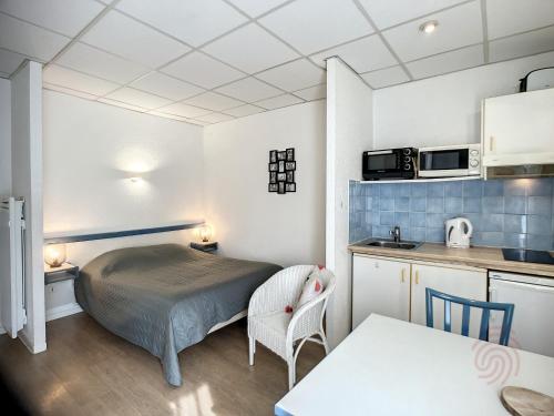 mały pokój z łóżkiem i kuchnią w obiekcie Studio lumineux avec balcon à 50m des Thermes - Animaux acceptés, Wifi, options confort disponibles - FR-1-451-176 w mieście Lamalou-les-Bains