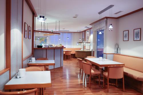 ein Restaurant mit Tischen und Stühlen und eine Küche in der Unterkunft Hotel Blaubeurer Tor in Ulm