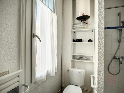 łazienka z toaletą, oknem i prysznicem w obiekcie Studio cosy proche des Thermes, centre-ville et nature, WiFi, animaux acceptés - FR-1-451-181 w mieście Lamalou-les-Bains
