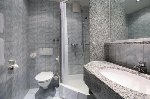 a bathroom with a tub and a toilet and a shower at Hotel Blaubeurer Tor in Ulm