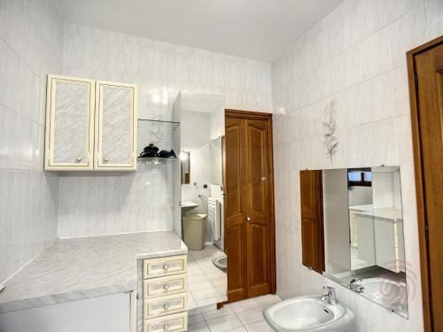 a white bathroom with a sink and a toilet at Maison Lamalou-les-Bains, 5 pièces, 6 personnes - FR-1-451-185 in Lamalou-les-Bains