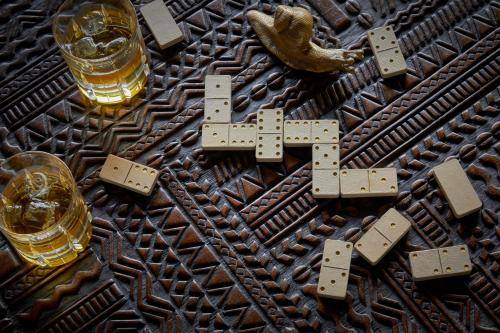 a wooden table with two glasses of beer and a wooden cross at One&Only Gorilla's Nest in Kinigi