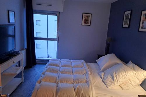 une chambre avec un lit avec des draps blancs et une fenêtre dans l'établissement Large apartment with sea view, à Le Touquet-Paris-Plage