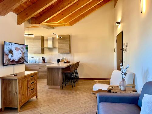 a living room with a blue couch and a kitchen at [Cotton Flower} Attico 15 minuti da Malpensa MXP in Busto Arsizio