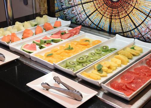 a buffet with several trays of different fruits and vegetables at Grums Hotel & Spa in Barcelona