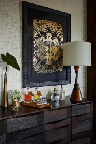 a table with a lamp and a picture on a wall at One&Only Gorilla's Nest in Kinigi