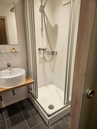 uma casa de banho com um chuveiro e um lavatório. em Posthotel Traube em Donauwörth