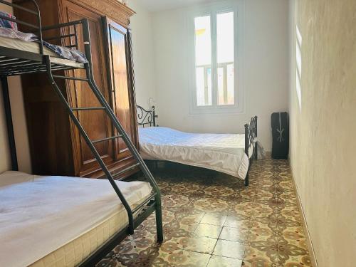 Cette chambre comprend 2 lits superposés et une fenêtre. dans l'établissement Maison Port-Vendres, 3 pièces, 6 personnes - FR-1-309-367, à Port-Vendres
