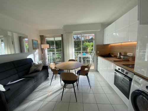 une cuisine et un salon avec un canapé et une table dans l'établissement Appartement T2 en Front de Mer à Arcachon, Accès Direct Plage, Parking, Animaux Admis - FR-1-374-201, à Arcachon