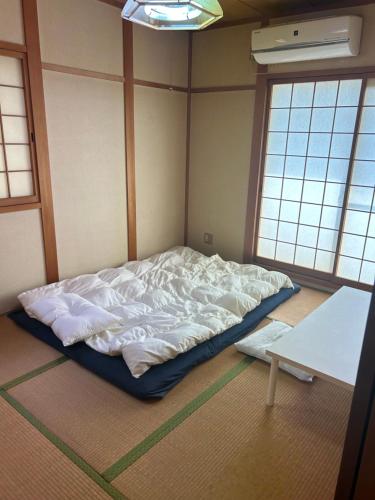 Cama grande en habitación con 2 ventanas en 無料駐車場付き個室 大阪と京都へアクセス 良し無人チェックイン, en Yawata