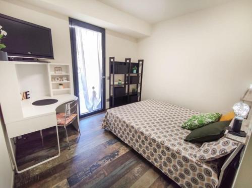 una camera con letto, scrivania e TV di Trilocale Laureati vista mare a 50m dalla spiaggia a San Benedetto del Tronto
