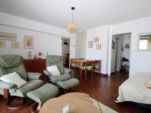 sala de estar con sillas verdes y mesa en Appartement Saint-Cyprien, 2 pièces, 4 personnes - FR-1-309-370, en Saint-Cyprien