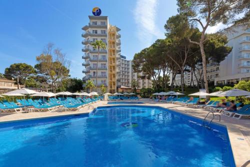 una gran piscina con sillas y sombrillas azules en Pabisa Sofia en Playa de Palma