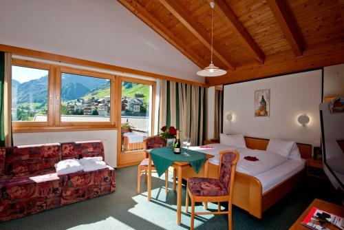 a hotel room with a bed and a table at Hotel Romantica in Samnaun