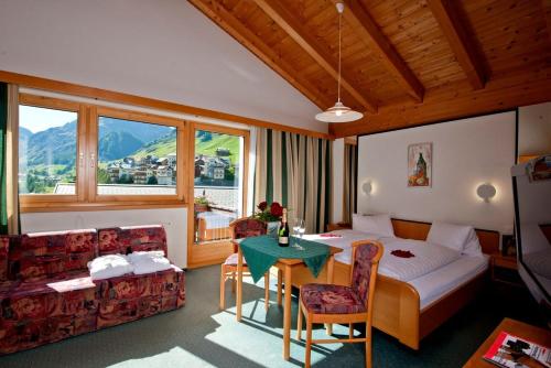 ein Hotelzimmer mit einem Bett und einem Tisch in der Unterkunft Hotel Romantica in Samnaun