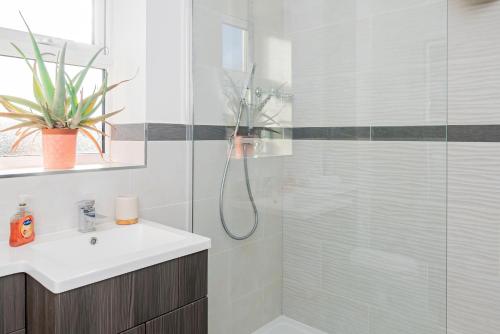 uma casa de banho com uma cabina de duche em vidro com um lavatório e um WC. em 2 Bed Free Private Parking Leisure Contractor em Higham Ferrers