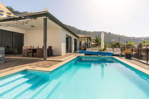 a large swimming pool in front of a house at Casa Mia, a Dream Spot With Heated Pool in Arco da Calheta