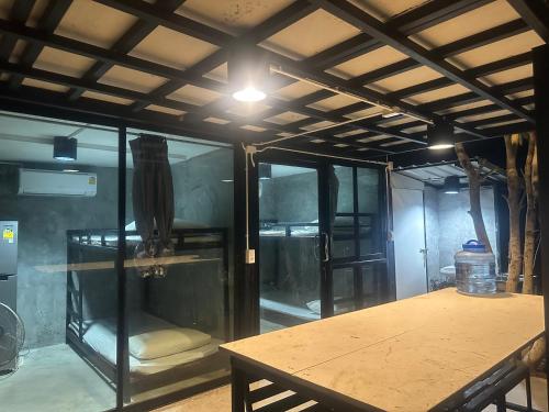 a room with glass walls and a table and a ceiling at ชลลดา ริเวอร์ โฮมสเตย์ แก่งกระจาน in Ban Wang Malako