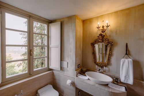 a bathroom with a sink and a mirror and a toilet at Castello di Casalborgone, Luxury Italian Castle Hotel in Casalborgone