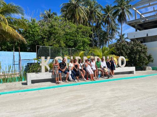 a group of people sitting in front of a sign at Konut by Thakuru in Guraidhoo