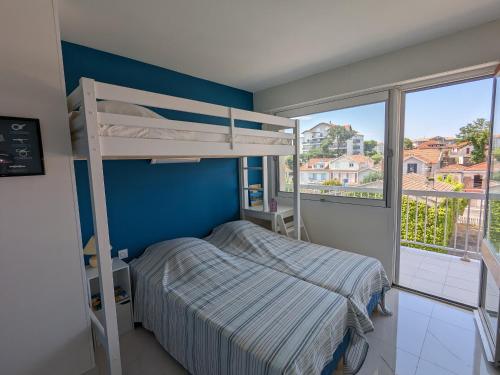 une chambre avec un lit superposé et une grande fenêtre dans l'établissement Grand T3 avec 2 terrasses et accès direct plage - FR-1-420-129, à Arcachon